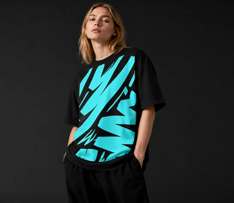 Model wearing the Shifft black tee with turquoise graphics